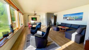a living room with a blue couch and chairs at Lofoten Red Villa in Laupstad