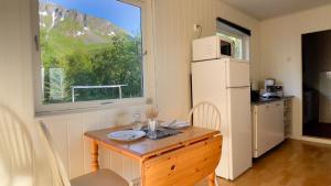 a small kitchen with a table and a refrigerator at Lofoten Red Villa in Laupstad