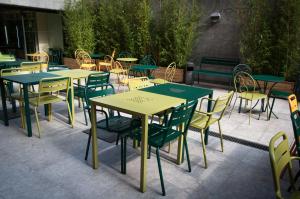 - un ensemble de tables et de chaises assises sur une terrasse dans l'établissement Alberg Pere Tarrés, à Barcelone