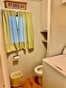 a bathroom with a toilet and a yellow curtain at White Caps Motel in Port Clinton