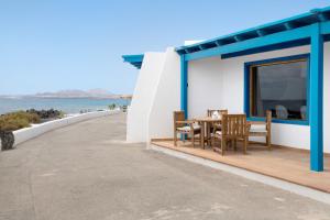 a house with a table and chairs next to the ocean at Welling in Punta Mujeres