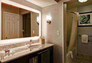 a bathroom with a sink, mirror, and bathtub at Poplar Inn and Suites in Memphis