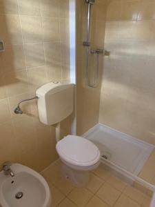 W łazience znajduje się biała toaleta i prysznic. w obiekcie Villaggio Benvivere w mieście Senigallia
