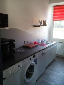 a kitchen with a washing machine and a sink at Escale Bussenette in Bussang