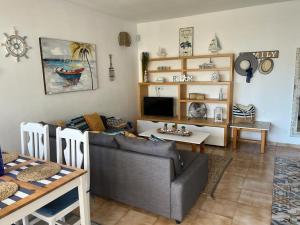ein Wohnzimmer mit einem Sofa und einem Tisch in der Unterkunft Primavera Tenerife Sur in Arona