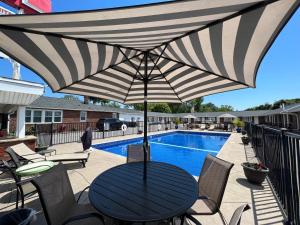 a table with an umbrella next to a pool at Moonlite Motel in Niagara Falls