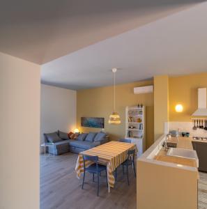 a kitchen and living room with a table and a couch at SaltoNelBlu in Porto Santo Stefano