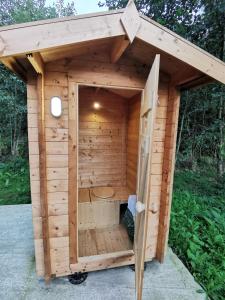 a small wooden sauna with a wooden roof at Charmant POD en bois près d'un plan d'eau in Nielles-lès-Ardres
