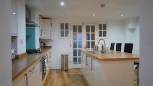 a kitchen with white cabinets and a wooden counter top at Modern & Spacious Leeds City Centre Apartment with Parking - Sleeps 5 in Leeds