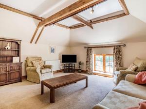 a living room with a couch and a table at Punch Cottage in Little Glenham