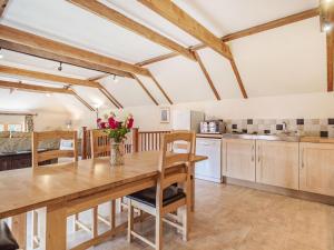 a kitchen and dining room with a wooden table and chairs at Punch Cottage in Little Glenham