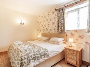 a small bedroom with a bed and a window at Punch Cottage in Little Glenham