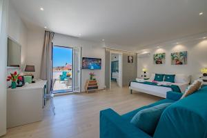 uma ampla sala de estar com um sofá azul e uma sala de estar com em Vittoria Luxury Rooms em Sciacca