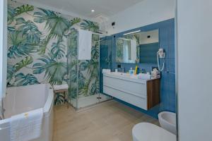 a bathroom with a blue wall with palm trees mural at Vittoria Luxury Rooms in Sciacca +34 photos
