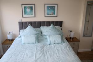 Una cama con sábanas blancas y almohadas en un dormitorio en Lovely 1 bedroom basement apartment with stunning views, en Bodfari