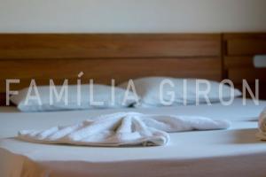 una cama con toallas blancas en ella con la palabra familiar un grupo en Flats a 100 mts da Praia, en Porto Seguro