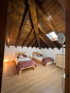 two beds in a large room with wooden ceilings at Torre Ortiz de Zárate 