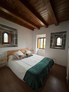 a bedroom with a large bed with two windows at Torre Ortiz de Zárate 