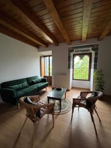 a living room with a green couch and chairs at Torre Ortiz de Zárate 