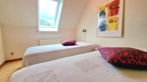 a bedroom with two beds and a window at Bornholm Majalis in Rønne