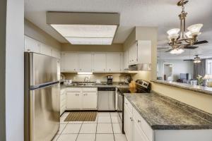 una cucina con armadi bianchi e frigorifero in acciaio inossidabile di Dolphin Point 303C Destin Condo a Destin
