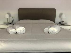 Una cama blanca con tres toallas blancas. en Chalet Meu Lar, en O Casal Pontevedra