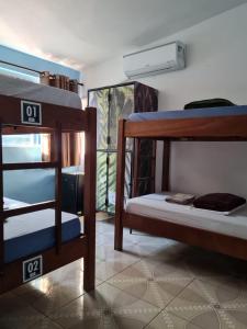 a room with three bunk beds and a window at Pousada e Hostel Paraíso Capitólio in Capitólio