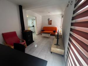 sala de estar con cama de color naranja y sofá en Apartamentos La Isla, en Lloret de Mar