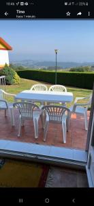 - une table et des chaises blanches sur la terrasse dans l'établissement Casa La Hayuela Molleda, à Ayuela
