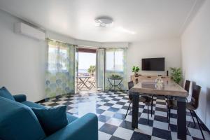 a living room with a blue couch and a table at Apartment T2 air-conditioned sea view in Saint-Laurent-du-Var