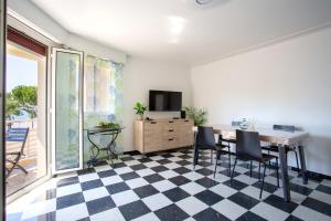 comedor con mesa, sillas y TV en Apartment T2 air-conditioned sea view, en Saint-Laurent-du-Var