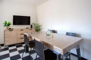 ein Esszimmer mit einem Tisch mit Stühlen und einem TV in der Unterkunft Apartment T2 air-conditioned sea view in Saint-Laurent-du-Var