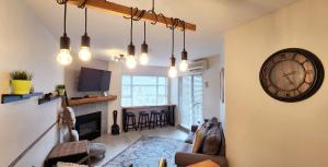 a living room with a clock on the wall at 1BR plus Den Village Condo with Mountain Views and Hot Tub by Harmony Whistler in Whistler +12 photos
