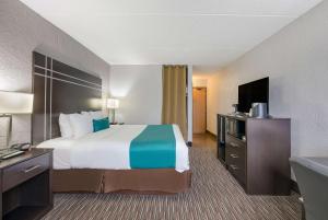a hotel room with a large bed and a television at Best Western Waukesha Grand in Pewaukee +31 photos