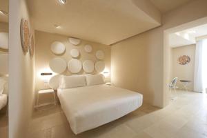 a bedroom with a white bed in a room at Palazzo Gatto Art Hotel & SPA - BW Premier Collection in Trapani