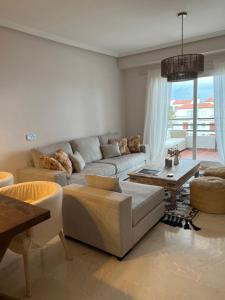 ein Wohnzimmer mit Sofa und Tisch in der Unterkunft Vistas al mar en Jardines del Mar Mediterráneo in Castillo de Sabinillas