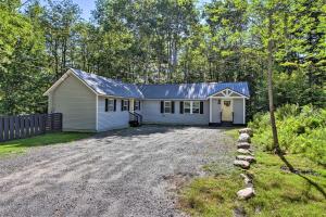 una pequeña casa blanca con entrada de grava en Stylish Mountain Home Near Ski, Golf and Manchester!, en Bondville