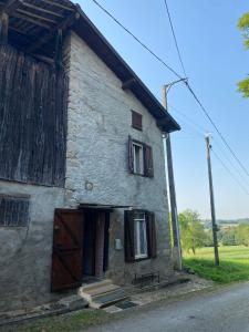 an old stone house with a wooden door and windows at Petit coin de paradis à 10 min de St-Girons in Montjoie-en-Couserans