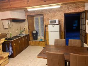 a kitchen with a table and a white refrigerator at Petit coin de paradis à 10 min de St-Girons in Montjoie-en-Couserans +6 photos
