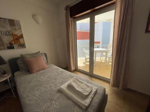 - une chambre avec un lit et une porte donnant sur une terrasse dans l'établissement M&M's Cosy apartment - Sea view, à Luz