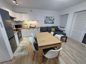 una cucina e un soggiorno con tavolo e sedie in legno di Apartament River Skierniewice a Skierniewice