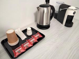 a tray with food and a coffee maker and a tea kettle at THE BEST SUITES & ROOMS - A pochi passi dalla kasbah - in Mazara del Vallo