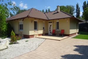 una casa con patio, tavolo e sedie di Liget a Balatonföldvár