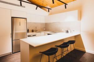a kitchen with a large counter with stools at Kunama Townhouses in Jindabyne