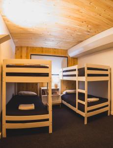 2 łóżka piętrowe w pokoju z drewnianym sufitem w obiekcie Kunama Townhouses w mieście Jindabyne