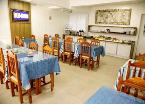 a restaurant with tables and chairs and a kitchen at Planaltur Hotel in Passo Fundo