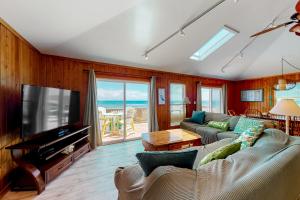 Una sala de estar con un sofá y un televisor de pantalla plana. en Dolphin Watch 224, en Frisco