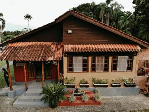 una pequeña casa con plantas delante en Casas Di Monte Ecopousada, en Morretes