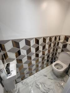 ein Bad mit einem WC und einer gefliesten Wand in der Unterkunft DaySpring White House - Dartford Kent in Kent