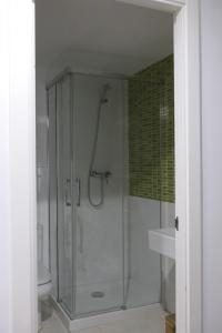 La salle de bains est pourvue d'une douche avec une porte en verre. dans l'établissement Apartament Ramon a Pobla, à Pobla de Segur